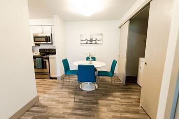 a dining room with a table and chairs and a kitchen at Aero Apartments, Washington, 98444